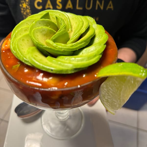 Casa Luna's Mexican shrimp cocktail, topped with fanned avocado slices and a lime wedge.