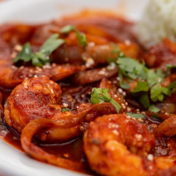 Close-up of Casa Luna's camarones a la diabla, spicy shrimp in red sauce with cilantro and rice.
