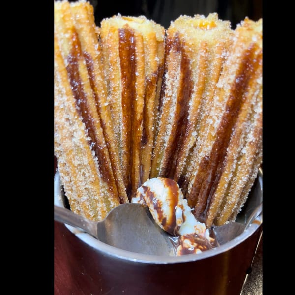 Casa Luna churros, sugar-dusted and drizzled with chocolate, served with vanilla ice cream.