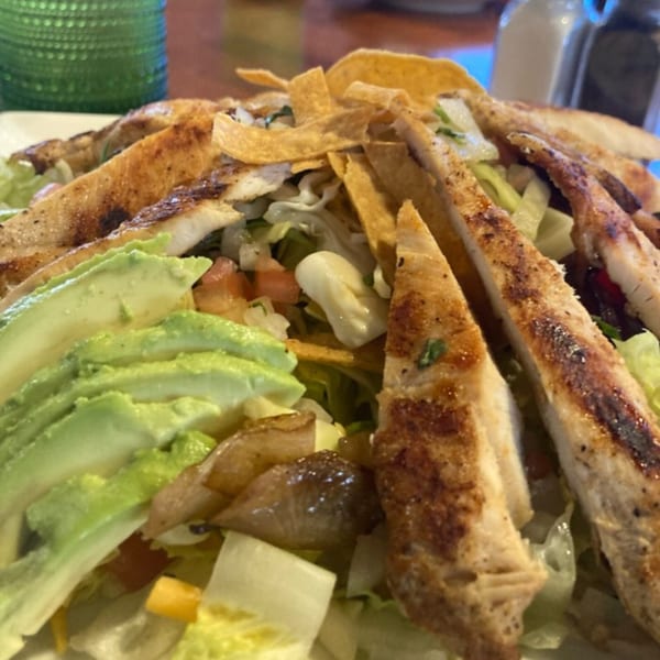 Grilled chicken salad with avocado, tortilla strips, and mixed greens, a Casa Luna Mexican Cuisine dish.